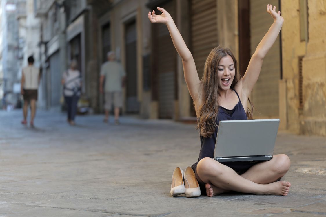 Person celebrating a small win at their laptop — the feeling of the first real sales