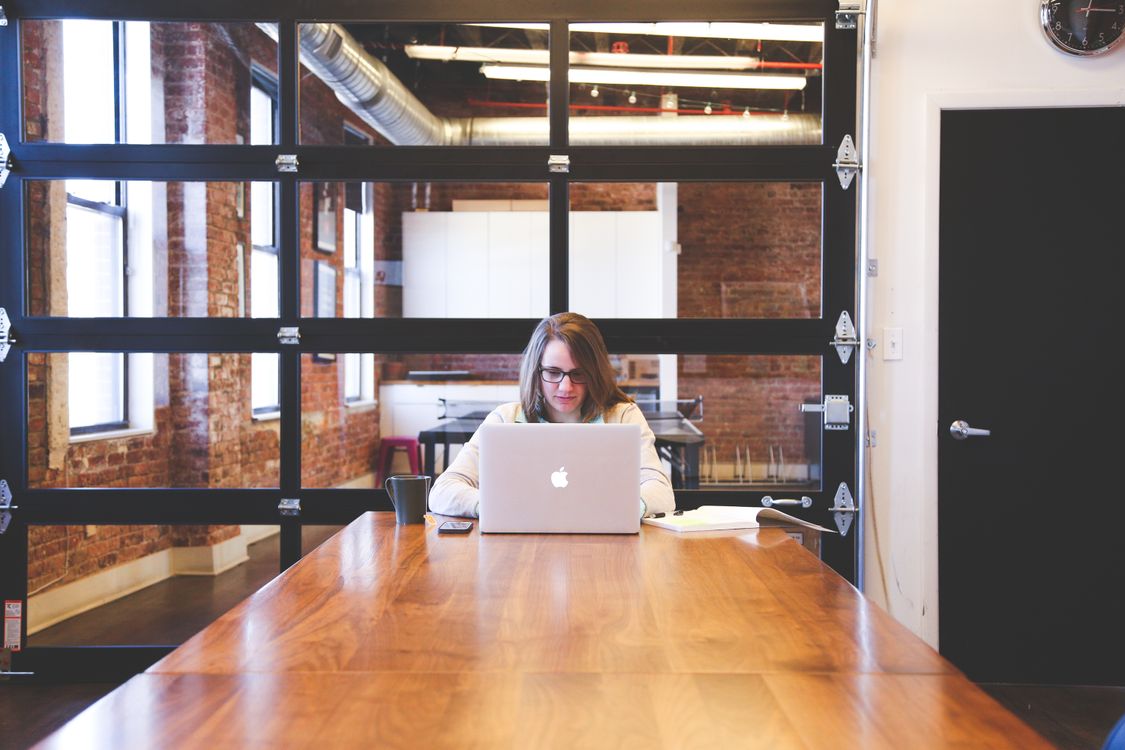 Young woman working on laptop in modern workspace — the grind of early product development